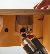 Removing a compact router to change bits without separating the sleeve and base plate from the table