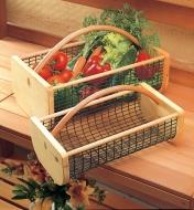 Large hod filled with vegetables next to an empty medium hod, sitting on a potting bench