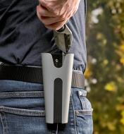 Pruners being slid into a pruner holster that is clipped to a belt