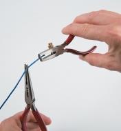 Holding wire with pliers while using Mini Wire Strippers to strip the end of the wire
