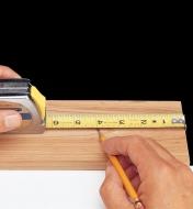 Marking a measurement on a board using a standard tape measure