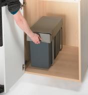 Gripping the Waste Container to slide it out of the cabinet