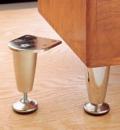 One cabinet leg installed in a cabinet with an uninstalled leg sitting next to it