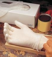 A woman wearing a glove liner under a vinyl glove