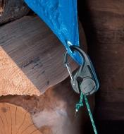 Nylon CamJam Cord Tightener holding a tarp over a woodpile