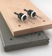 Two countersink drills placed on two boards with countersunk holes drilled into them