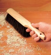 Brushing sawdust off a work surface