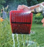 Rinsing berry scoop with a hose