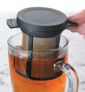 Brew Basket being lifted out of a glass mug of tea