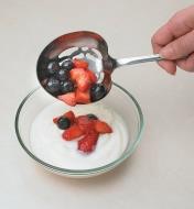 Berry Spoon scooping berries onto a bowl of yogurt