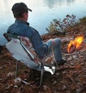 A man sitting in a lawn chair with the Campfire Back Warmer attached