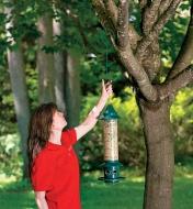 Hanging a bird feeder in a tree using a large garden hook