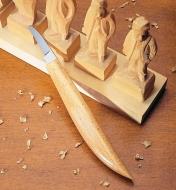 Couteau de sculpteur allemand no 8 à côté de figurines sculptées dans du bois