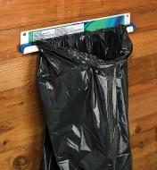Flat Bag Holder mounted on a wall, holding a black trashbag