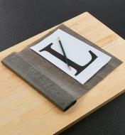 Paper and pencil lying on graphite tracing paper that has been used to trace a design onto wood