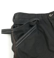 Close-up of pouch tucked into pocket of black pants