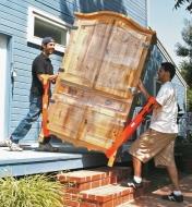 Two men carry a wardrobe down porch steps using Forearm Forklifts