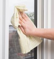 Wiping a windowpane with a Green Stripe Glass Towel