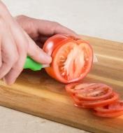 Personne coupant une tomate avec un couteau à tout faire