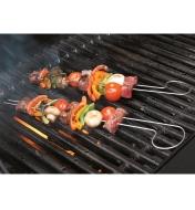 Meat and vegetables on two double-prong skewers being grilled on a barbecue