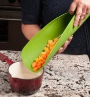 Transferring carrots from the Flexible Cutting Mat into a saucepan