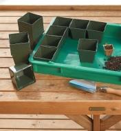 Giant Plant Tray being filled with square plastic pots on a potting table