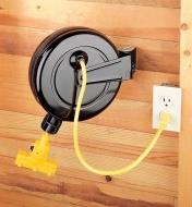 Cable reel mounted to a wall with the cord plugged into an outlet