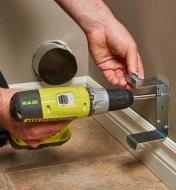 Attaching the bracket to the wall using a power drill
