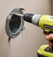 Attaching the steel collar to the wall using a power drill