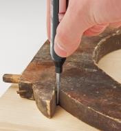 Using the fine-point tip to trace a shape onto a piece of wood