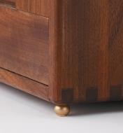 Round brass box foot installed on a cabinet