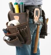 A man wearing a belt with two pouches and a hammer holder