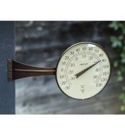 Thermomètre à grand cadran monté sur son support vissé à un poteau extérieur