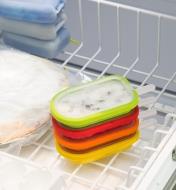 Ice pop molds stacked in a freezer drawer