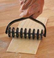 Rolling the Marcato Pasta Cutter over a sheet of pasta to cut it into strands