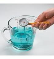 Using the extension handle on the Instant-Read Thermometer when checking the temperature of liquid in a measuring cup