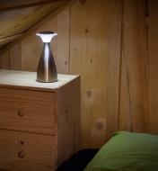 Lampe Lanterna sur une commode près d'un lit