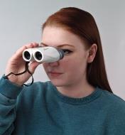 A young woman holds the Lightweight Compact Binoculars up to her eyes