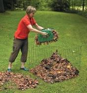Femme déposant des feuilles ramassées avec des ramasse-feuilles dans un composteur