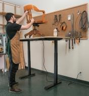 Piétement de table motorisé soutenant une surface de travail dans un atelier
