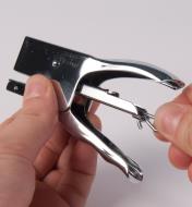 Unhooking the spring-loaded staple pusher inside the stapler