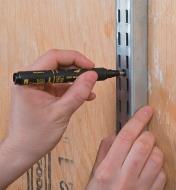 Marking a drill hole for a shelving unit using a Pica-Ink Indelible Pen
