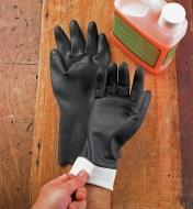 Putting on neoprene gloves next to a container of paint remover