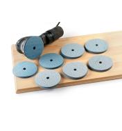 Seven piles of sanding discs sitting next to a sander