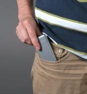 A man slips a roll of duct tape into his pants pocket