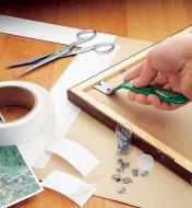 Driving glazier's points into a wooden picture frame with a PushMate Tool