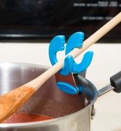 Pot Clip attached to the side of a pot, holding a wooden spoon