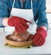 Oven gloves worn while handling a meat thermometer