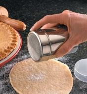 Using the flour shaker to shake flour onto pastry 