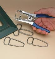 Using pliers to apply clamps to a picture frame